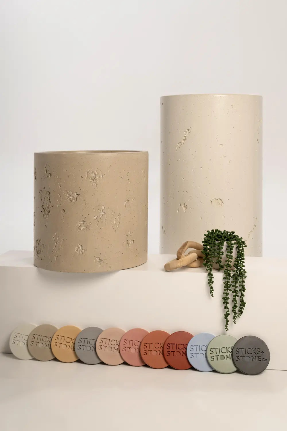 Concrete basin displayed with color sample discs in earthy tones