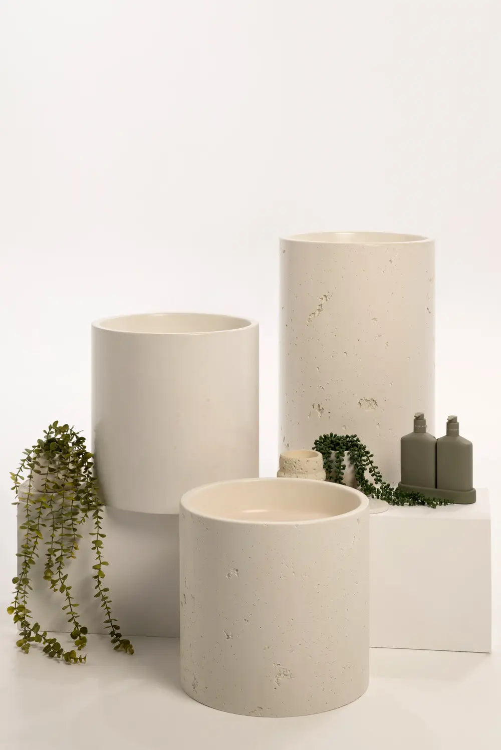 Three concrete basins with botanical styling and olive bottles