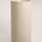 A standalone cylindrical concrete basin in a neutral beige tone, showcasing its smooth finish against a plain background.