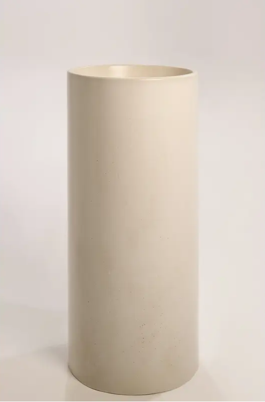 A standalone cylindrical concrete basin in a neutral beige tone, showcasing its smooth finish against a plain background.