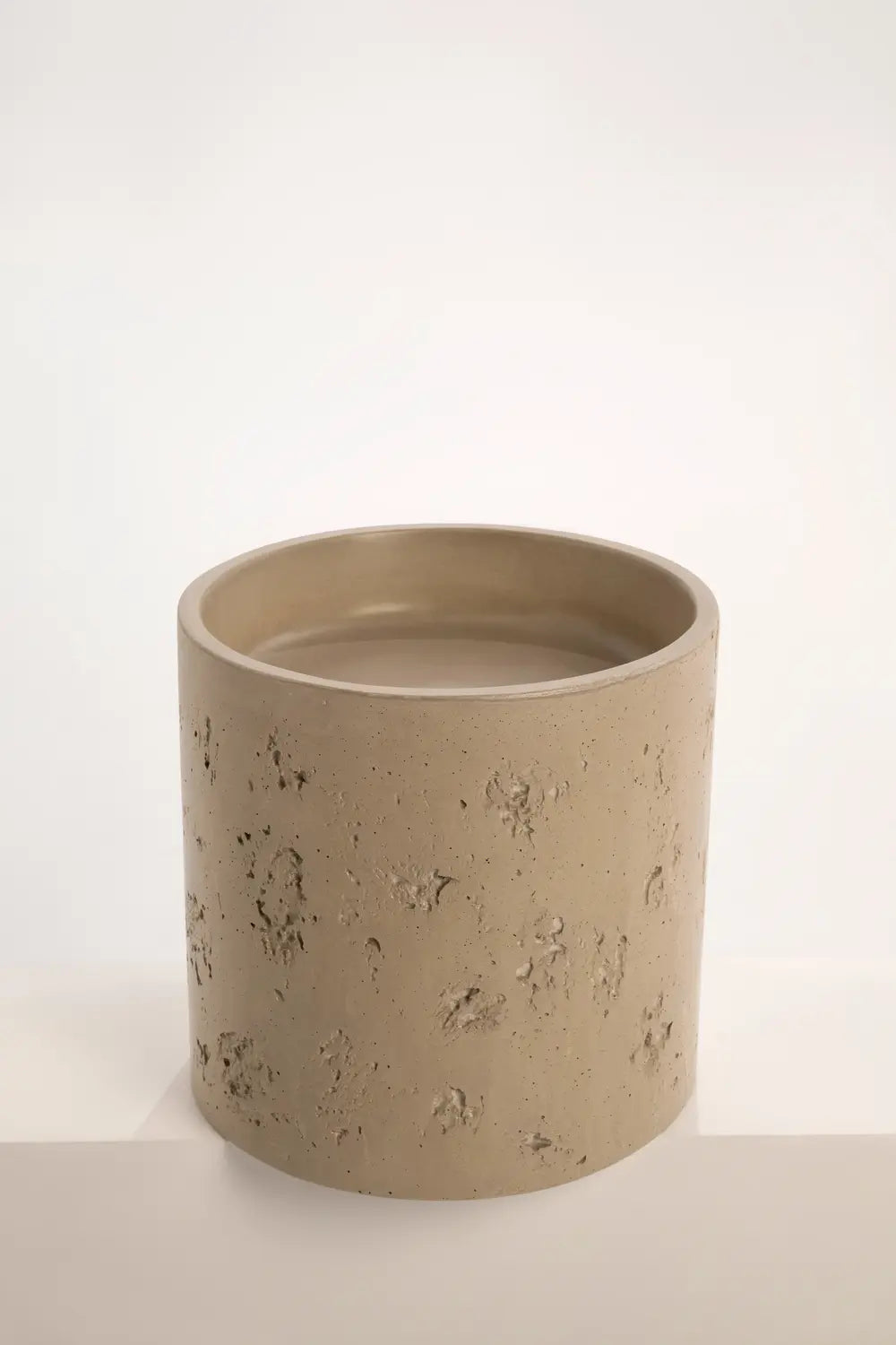 Taupe concrete pedestal basin showing rustic surface texture.