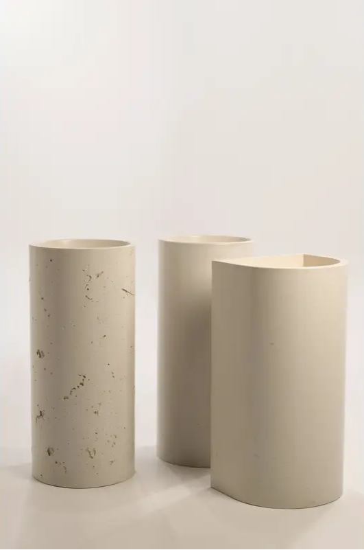 A set of three concrete basins with varying designs, including smooth and textured finishes and semi-circular cuts, displayed against a plain background.